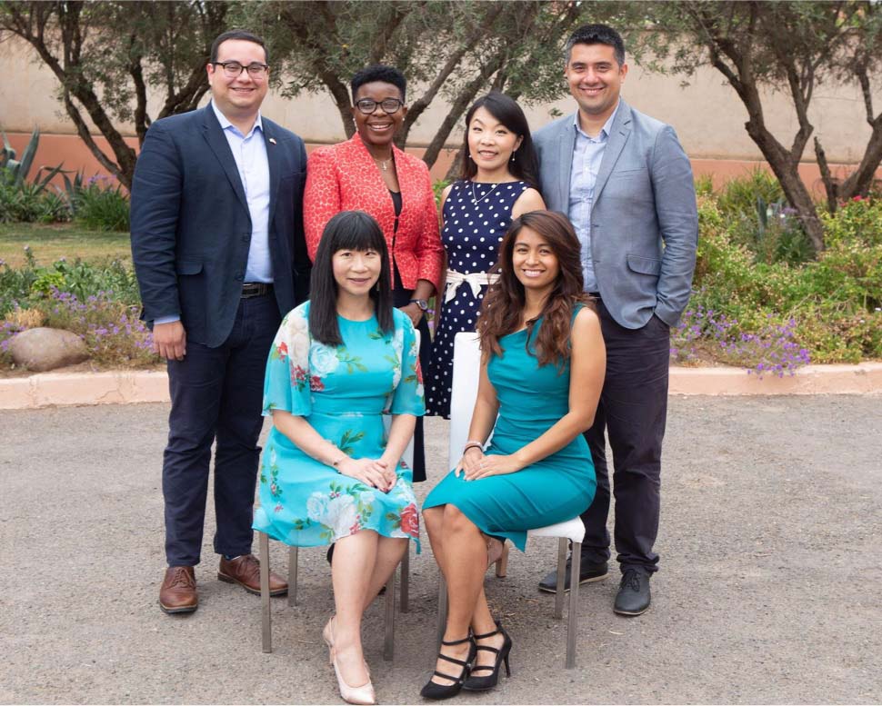 Exterior of six ICANN employees standing and sitting together.