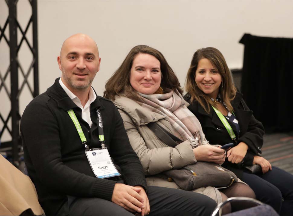Three ICANN employees seated together at an ICANN meeting.